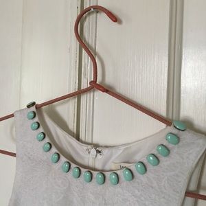 White lace dress with teal stone accents